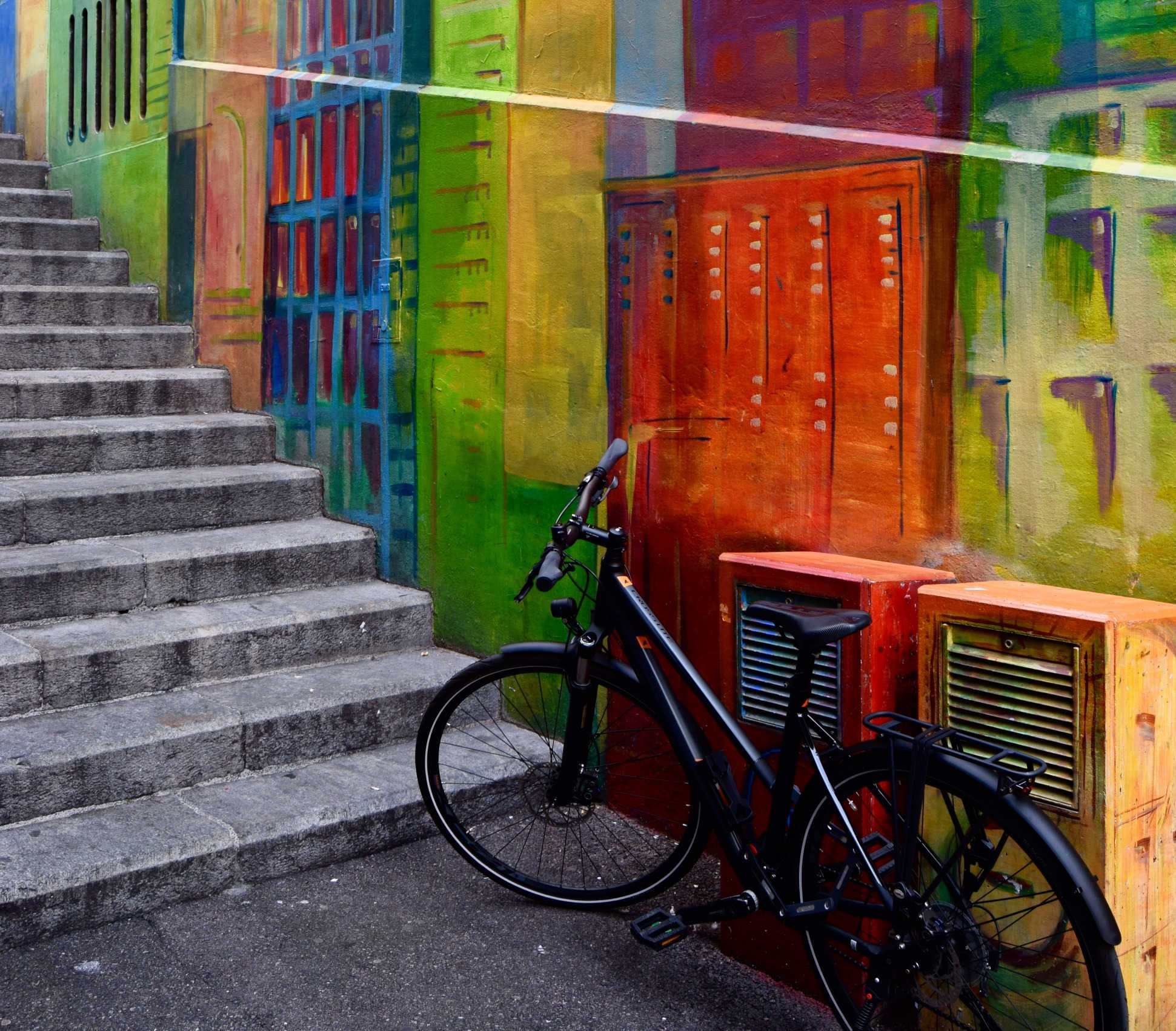 Bike leaning against colourful stairway
