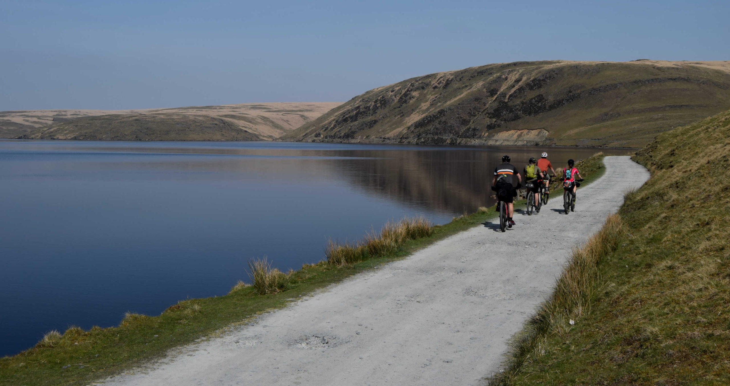 Group cycling alongside a lake